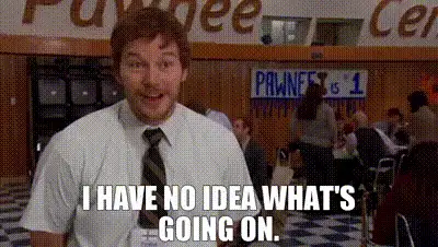 A confused man in a shirt and tie in a busy office, captioned: I have no idea what's going on.