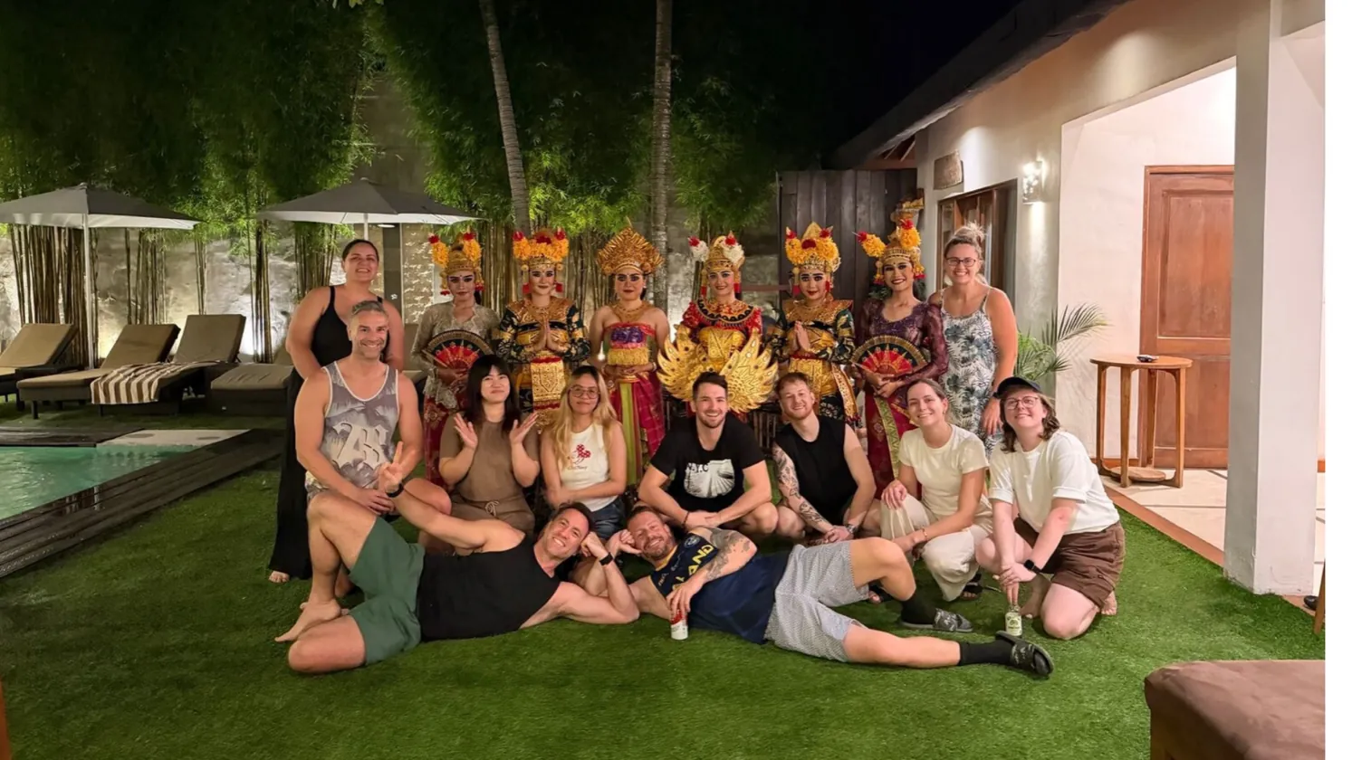The whole crew on the lawn with Balinese dancers in full headdress behind them