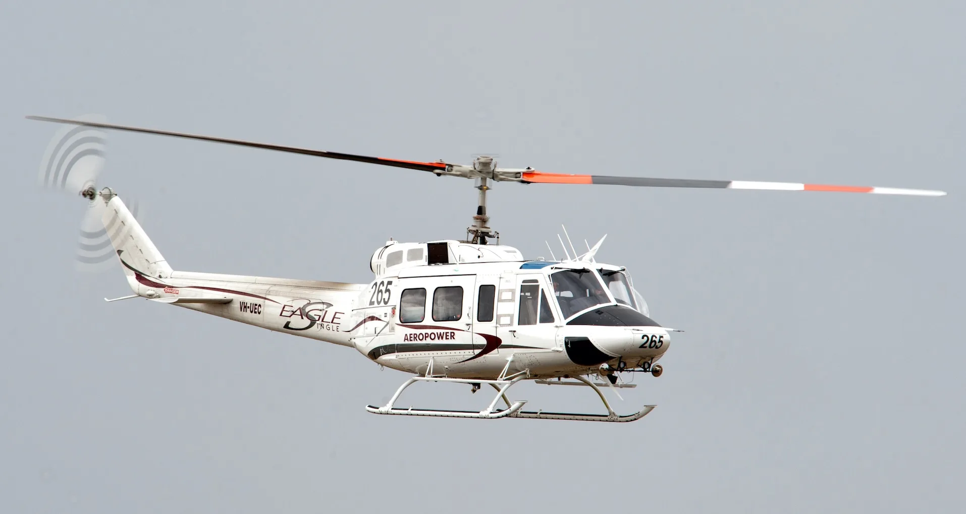 A white helicopter in Aeropower livery in flight against a grey sky